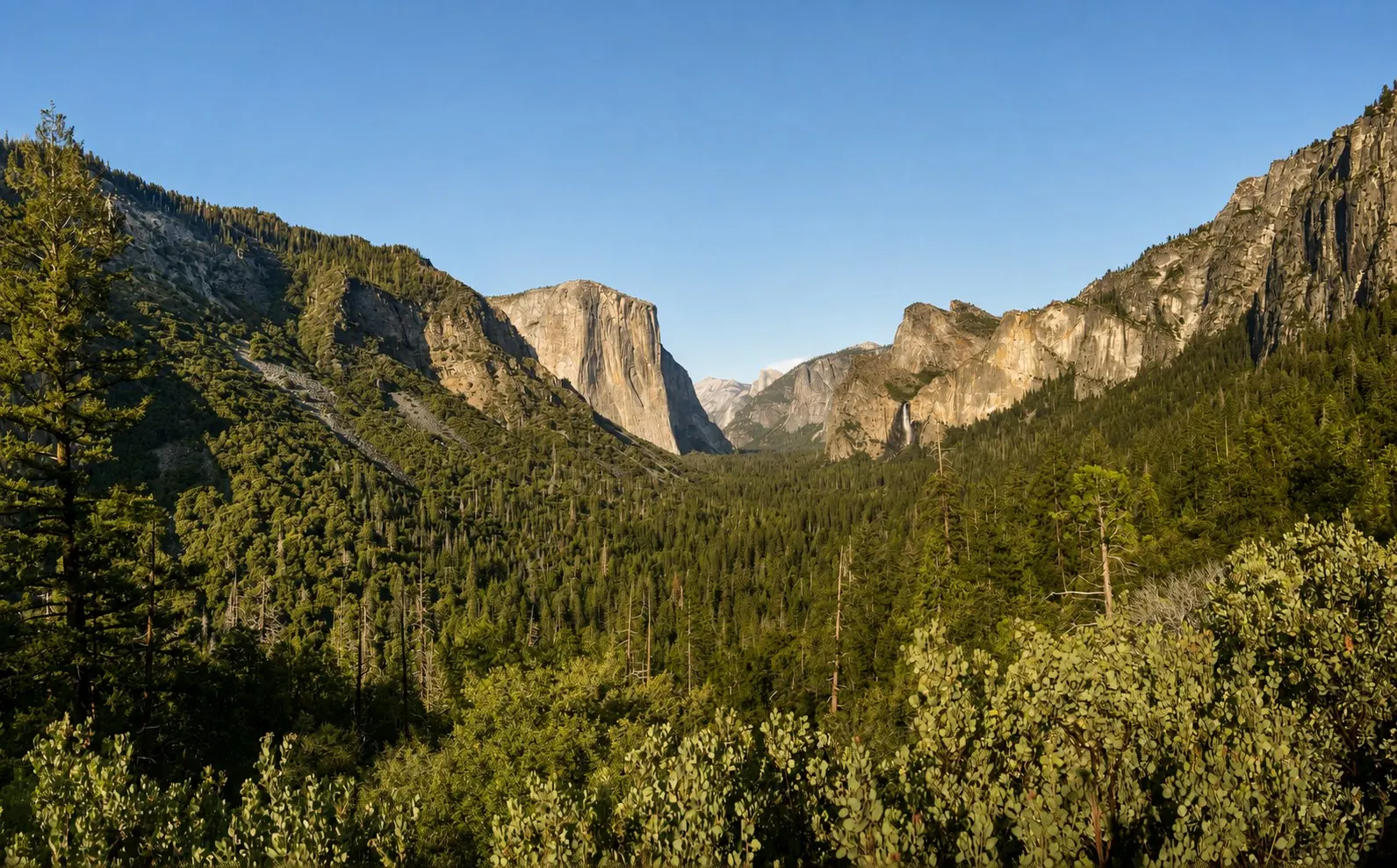 AI-enhanced view: El Capitan, Bridalveil Fall, and the forested Yosemite Valley seen from Tunnel View in California.